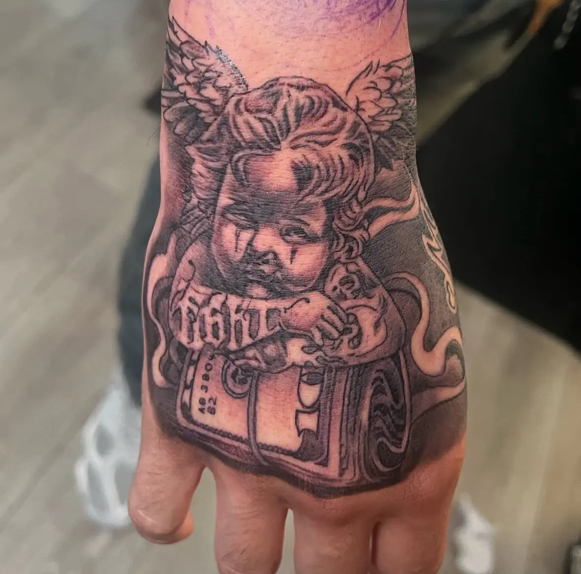Black-and-gray illustrated hand tattoo